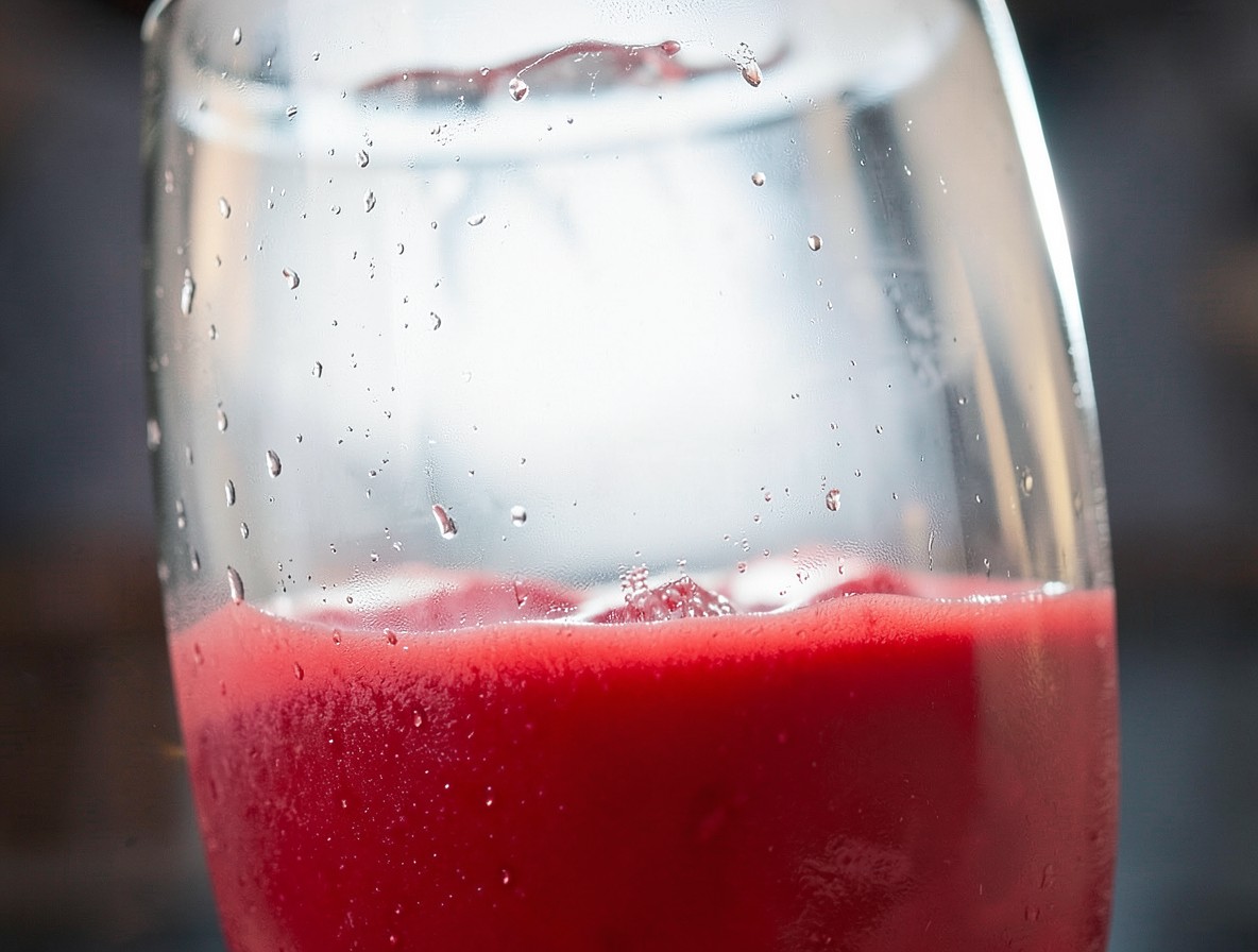 Close-up of the red strawberry puree layer at the bottom of a glass.
