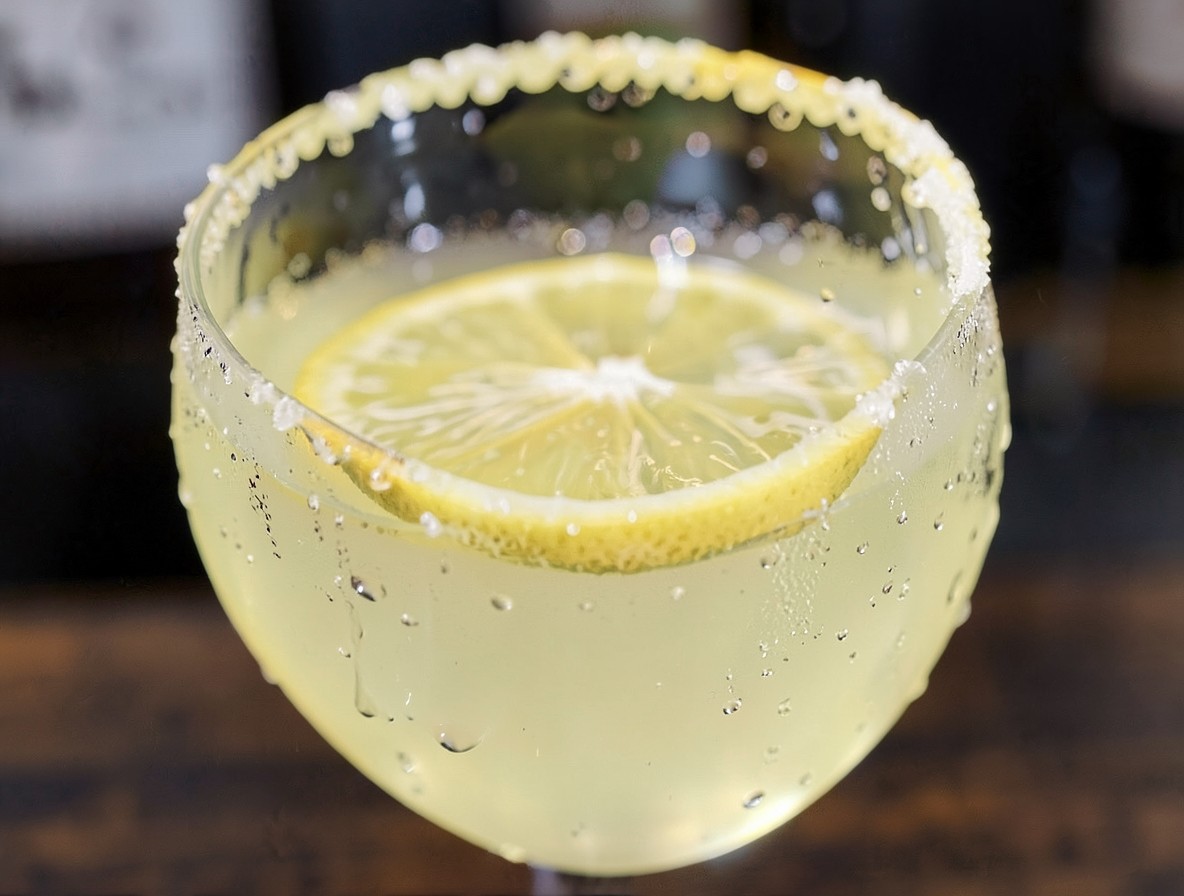 Macro shot of a finished Lemon Drop Martini with lemon wheel and sugar rim