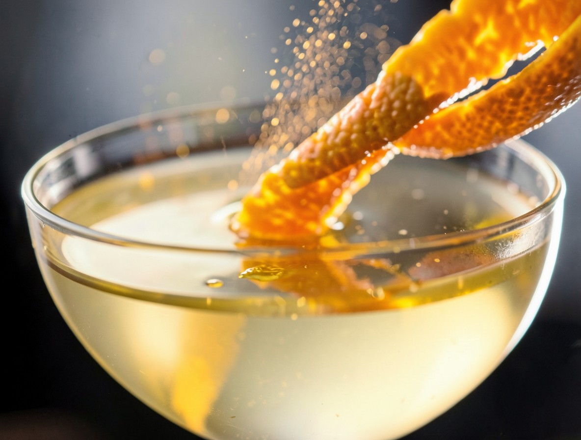Expressing orange oils over the Paradise cocktail.