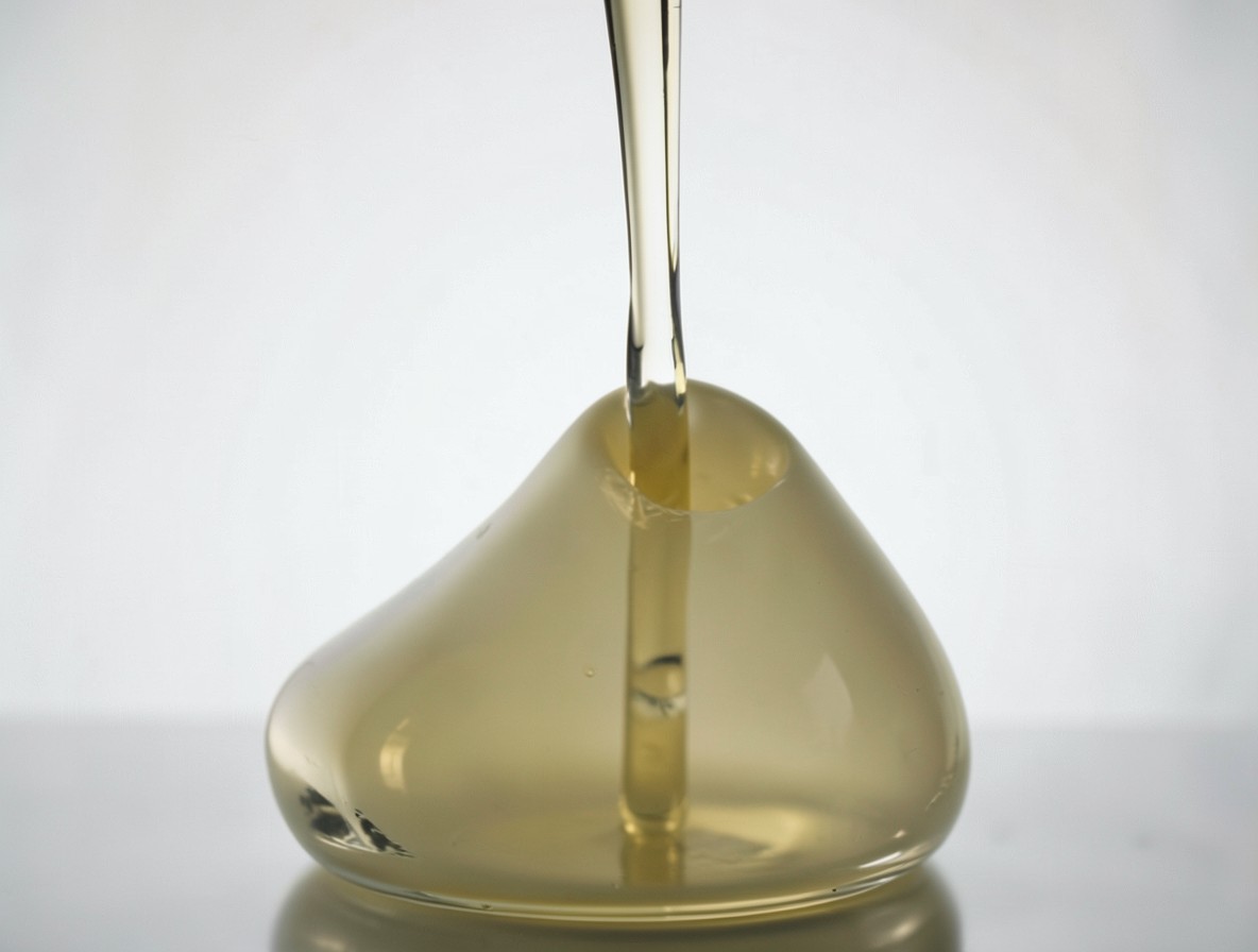 Pouring thick piña colada from blender into a highball glass