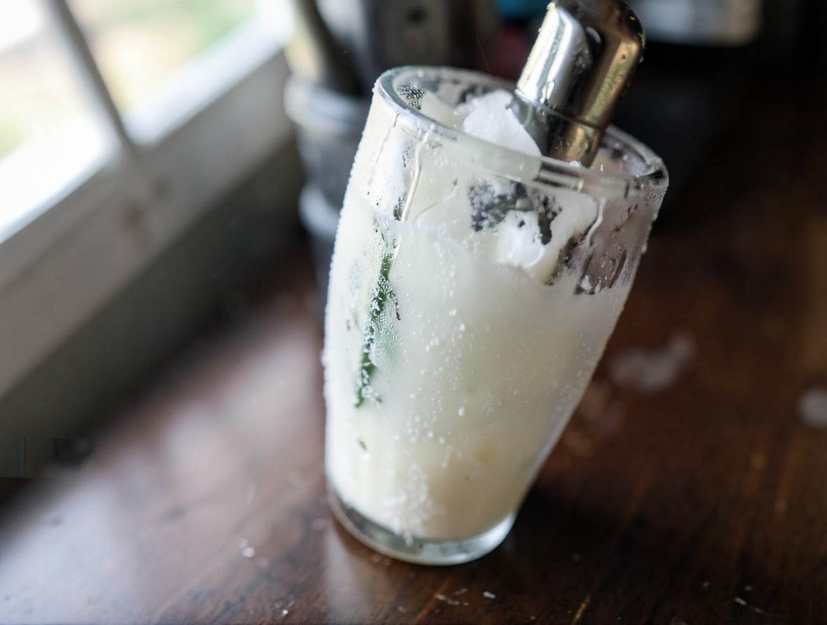 Cocktail shaker with frost and condensation being shaken